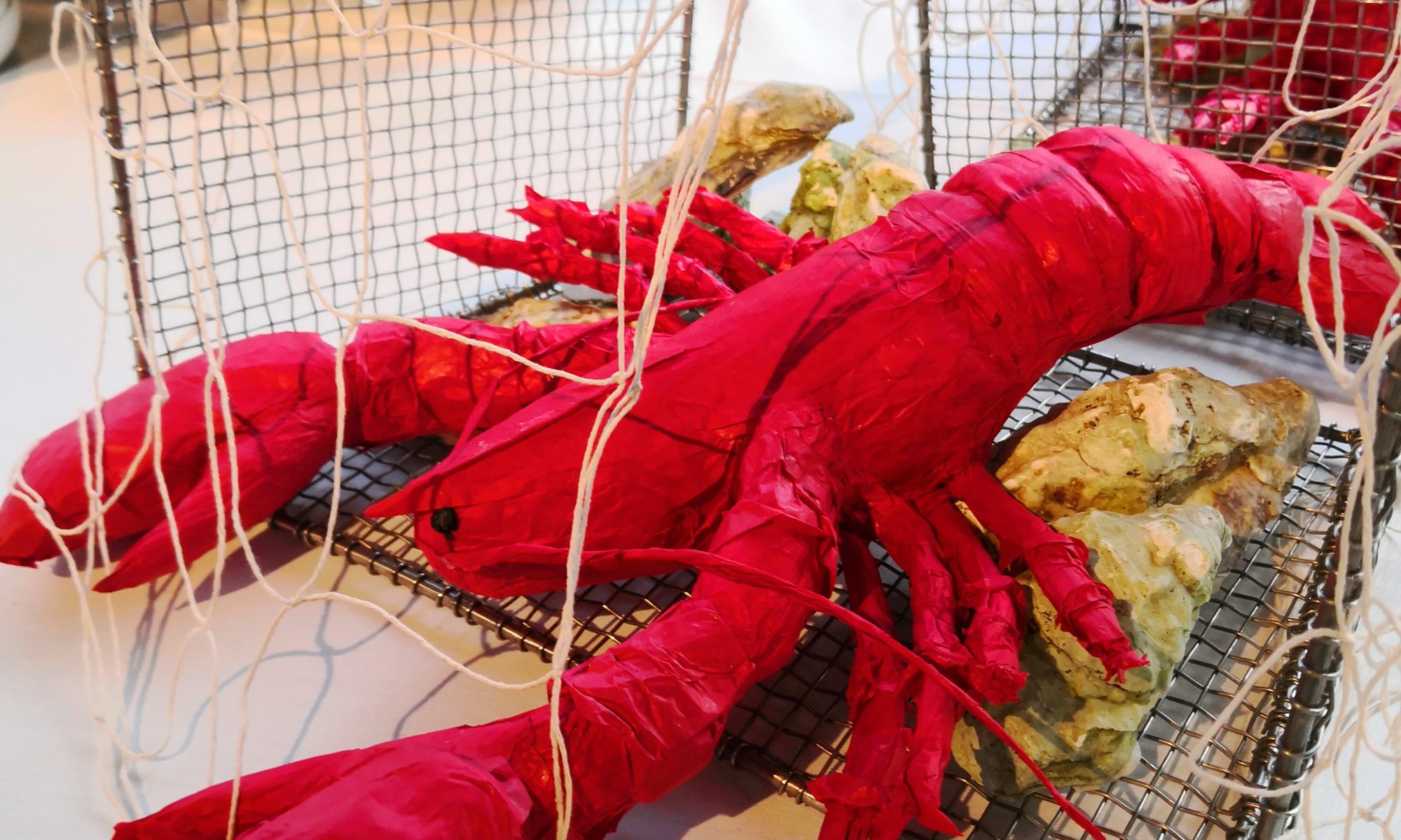 Décoration écoresponsable représentant un homard rouge vif fabriqué en papier de soie, idéale pour embellir votre événement ou décorer une vitrine.