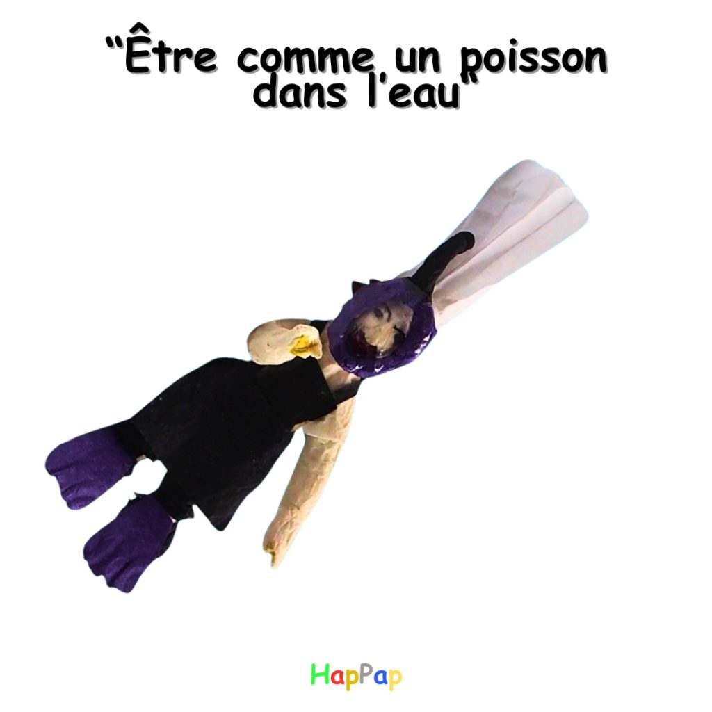 Illustration artistique en papier recyclé représentant l’expression « être comme un poisson dans l’eau », utilisée pour l’apprentissage du français de manière créative.